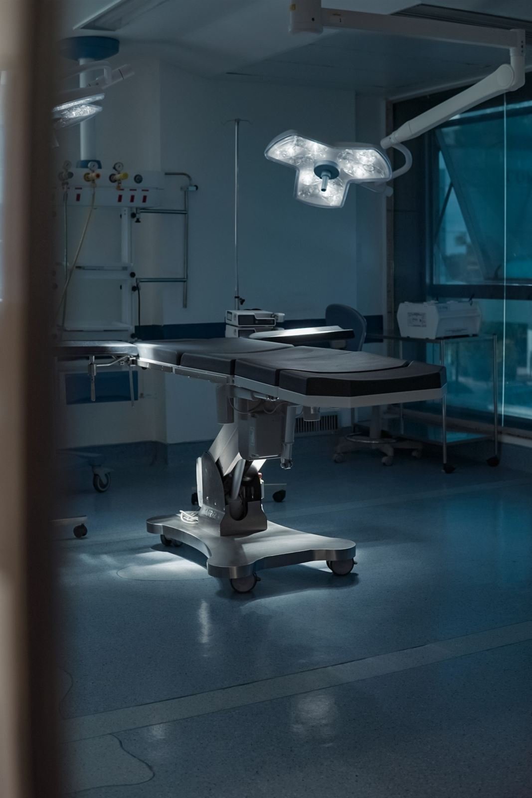 Sala cirúrgica com mesa operatória iluminada pelo foco